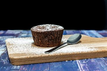 Coulant y cuchara de postre sobre mesa de madera