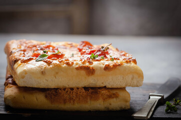 Focaccia pugliese with  oregano tomato and olive oil on wooden table.