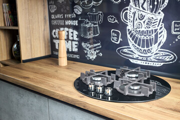 Modern kitchen equipment concept black tempered glass round shape gas hob with cast-iron grill with...