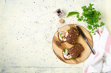 Healthy sandwich with rye bread with cream cheese, smoked salmon on wooden table.