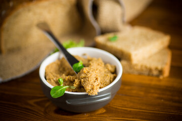 homemade meat pate in a ceramic bowl on a wooden table