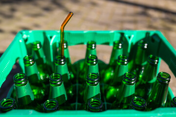 Ein Strohhalm in einer leeren grünen Bierflasche