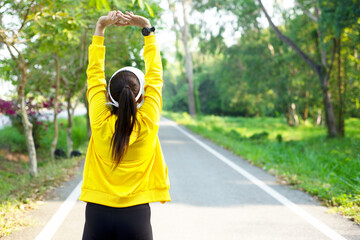 Healthy athletic woman warming up before go running to be fresh in the nature park. Asian runner woman after exercise. Healthy and Lifestyle concept. On Nature background..