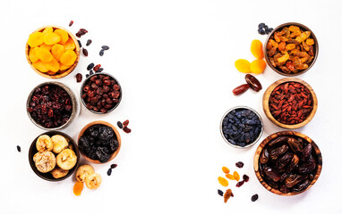 Healthy food snack: dried fruits, natural. sun dried organic mix of dried apricots, figs, raisins, dates, cranberries, cherries, goji berries, prunes in bowls on white background, top view