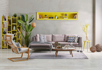 Decorative grey sofa and wall background stone style. yellow niche, home accessory, yellow bookshelf concept, poster frame orange lamp decor.