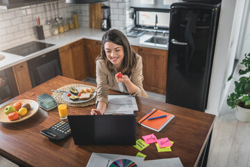 Young business entrepreneur woman working at home while having breakfast