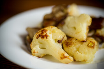 fried cauliflower with wild porcini mushrooms and onions in a plate