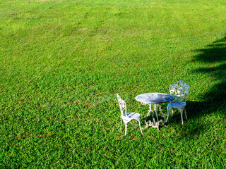 Obraz na płótnie Canvas Empty vintage wrought iron garden round table and two chairs.