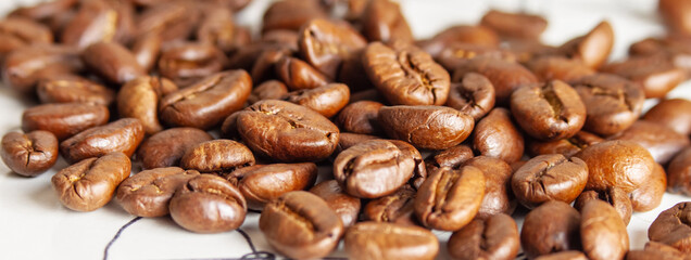 Freshly roasted coffee beans close-up on a white table