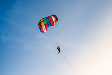 Parasailing in blue sky. Sports, active leisure, travel, vacation concept