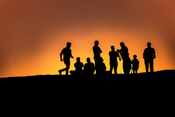 Fototapeta na wymiar PEOPLE ENJOYING THE SUNSET AT A SEA SIDE