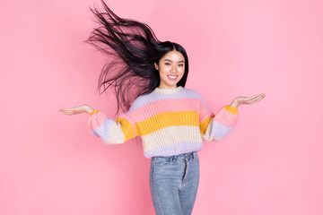 Photo of young smiling beautiful korean girl with flying hair promoting hair care treatment isolated on pink color background