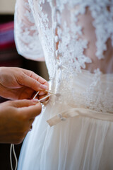 bridesmaid tie a ribbon on the corset of the bridesmaid dress