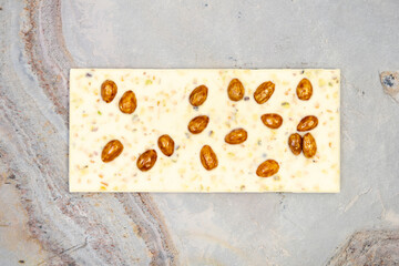 Sweet and delicious whole chocolate bar lies on light stone background photo taken from above in studio