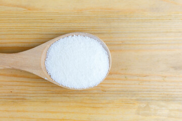 Pure Collagen Powder in wooden spoon.