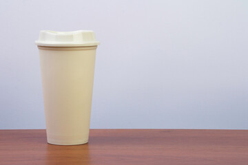mockup paper coffee cup on wood table with grey background, with copy space