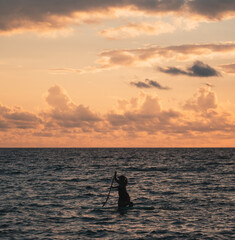 silhouette of a surfer in the sunset florida horizon clouds orange 