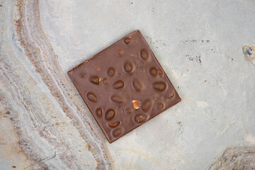 Sweet and delicious whole chocolate bar lies on light stone background photo taken from above in studio