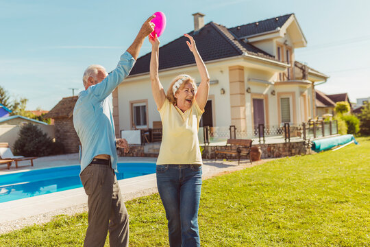 Senior Couple Having Fun Playing Toss And Catch