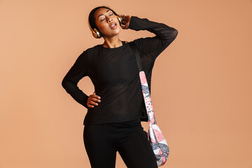 Focused african american woman singing while listening music with headphones
