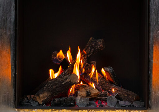 Wood logs burning in fireplace close up