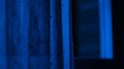 Blue window. Window with a woman. Halloween. Scary woman. Blue window with a woman.  Wind in the window. Horror. Fear. Dark window. Dark. 