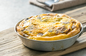 Omlet with mushrooms in a pan on a concrete background. Fritata is an Italian breakfast dish.