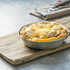 Omlet with mushrooms in a pan on a concrete background. Fritata is an Italian breakfast dish.