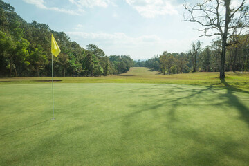 Background of evening golf course has sunlight shining down at golf course in Thailand. Nice scenery on a golf course at a late summer afternoon.