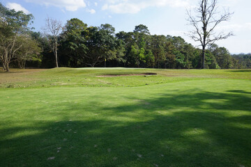 Background of evening golf course has sunlight shining down at golf course in Thailand. Nice scenery on a golf course at a late summer afternoon.