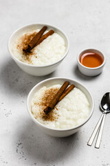 Healthy breakfast, coconut milk, cinnamon rice pudding in bowls. Space for text.