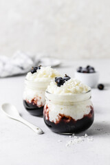 Healthy dessert rice pudding with blueberry jam  in glass jars. Space for text.