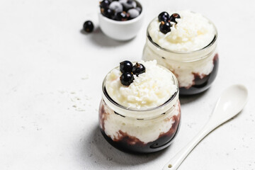 Deleicious rice pudding with frozen berries  in glass jars. Space for text, top view.