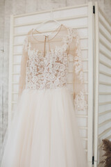 Wedding dress hanging against a wooden background