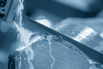 The automatic band saw machine cutting the metal bar with coolant method. The machine tool for...
