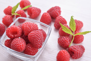 Raspberries in a bowl on a wooden textured background