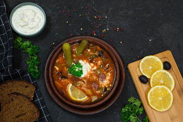 a national dish of Russian and Ukrainian cuisine. meat soup with pickles, olives, onions and lemon. with sour cream 