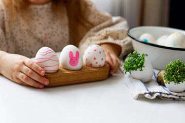 Little girl holding  paints easter eggs. Easter bunny.	Preparing for Easter. Happy easter.