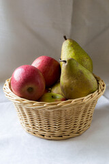 A wicker basket filled with apples and pears