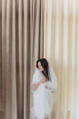 boudoir portrait of a young girl in a dressing gown, morning gatherings of the bride, fitting a wedding dress, young brunette, tender photo, wedding portrait