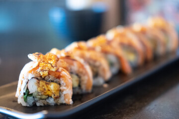 Salmon Engawa roll served on the black tray.