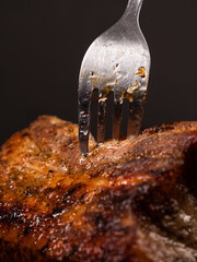 fork in a fried piece of meat, juicy pork closeup