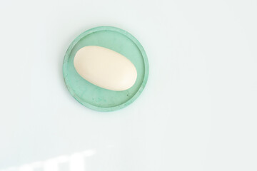 Soap on a mint color dish. Beauty, spa and wellness concept - close up of soap on gypsum tray.