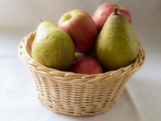 A wicker basket filled with apples and pears