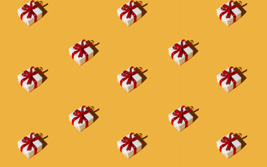 Gift pattern. Orange seamless background. Special day greeting. Holiday congratulation. Symmetrical composition of presents in white boxes with red ribbon bows isolated on bright yellow.