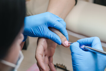 Manicurist applies pink gel to nails, close-up