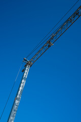 A crane on a construction site with a clear blue sky as a background. perfect copy space