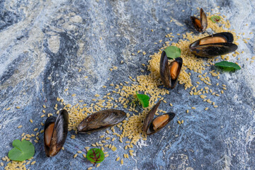 Raw mussels with spices on ice. On a blue background. Free space for text.