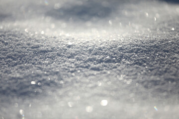 Snow close-up, winter background with copy space, glittering snowflakes with bokeh.