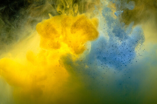 Fluid art. Abstract background. Yellow-blue flow on black.